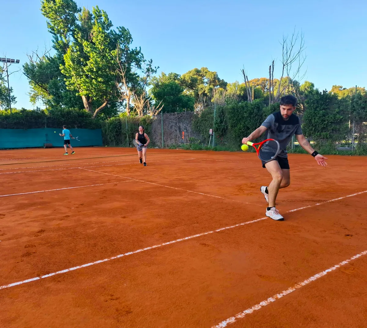Cancha de tenis en Núñez con jugadores